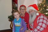 Six-year-old Summer Scott gets a sit down with Santa and Mrs. Claus at the Sarah Mooney Museum.